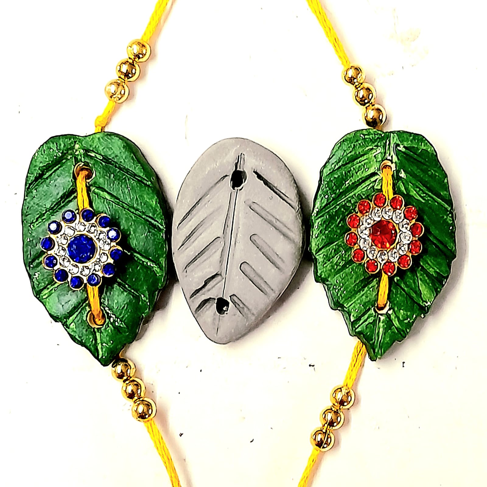 Handmade leaf-shaped rakhi with decorative stones crafted using clay in an art and craft workshop